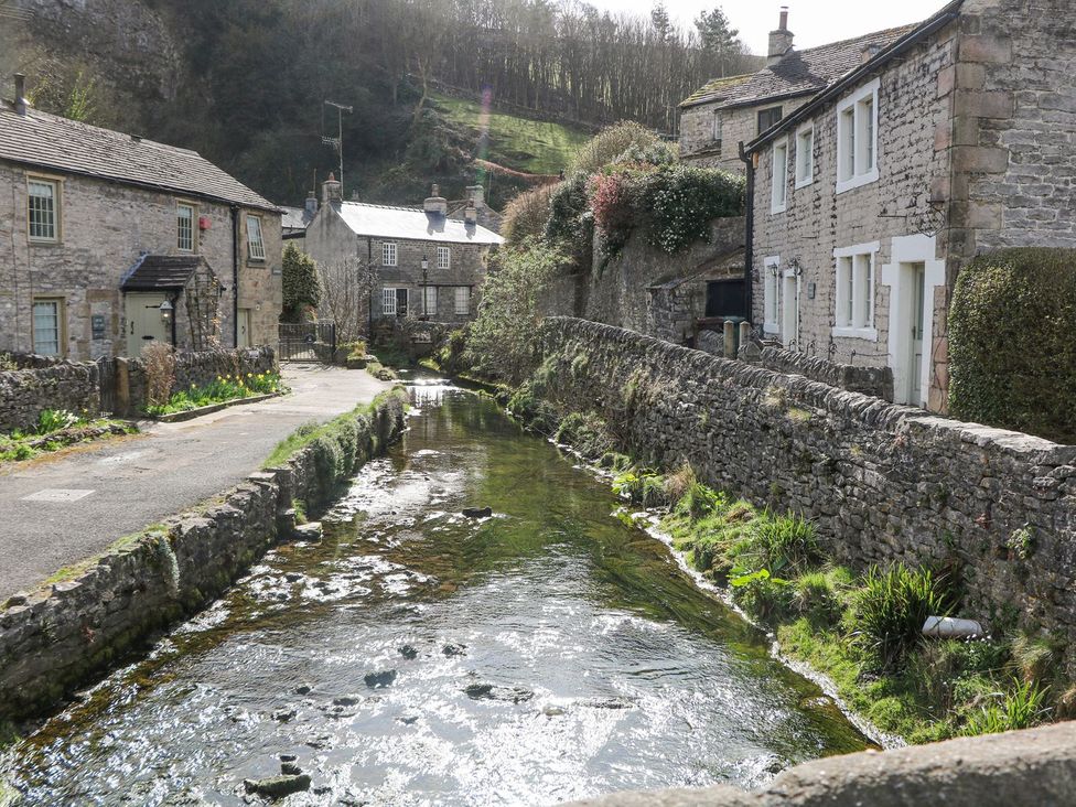 A street with houses and a river flowing next to them at Bradshaw House in Hope Valley
