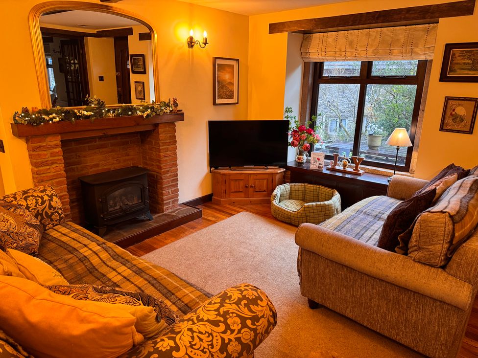 A living room with a sofa and television at Bradshaw House in Castleton, Peak District