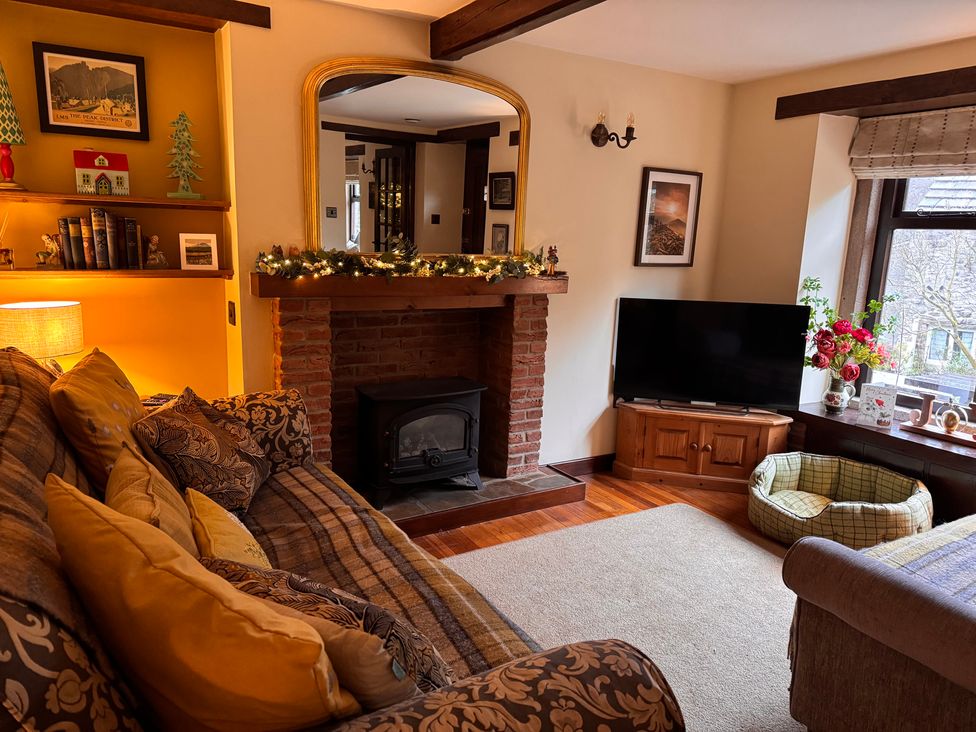 A living room with a fireplace and sofa at Bradshaw House, Castleton, Peak District