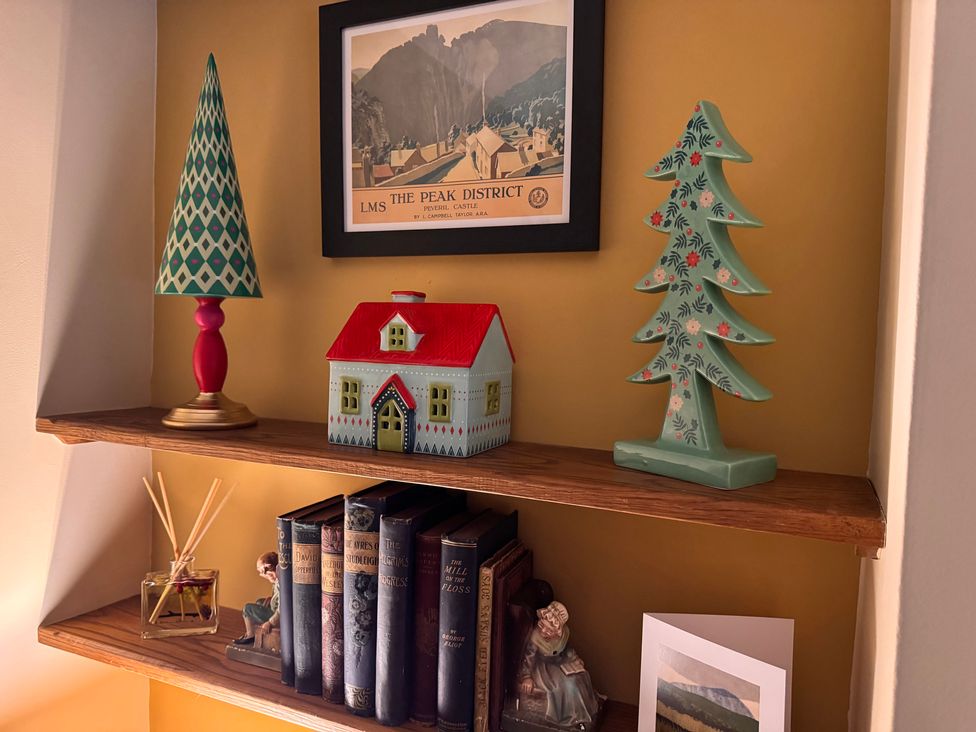 A shelf with decorative items and books at Bradshaw House, Castleton, Peak District