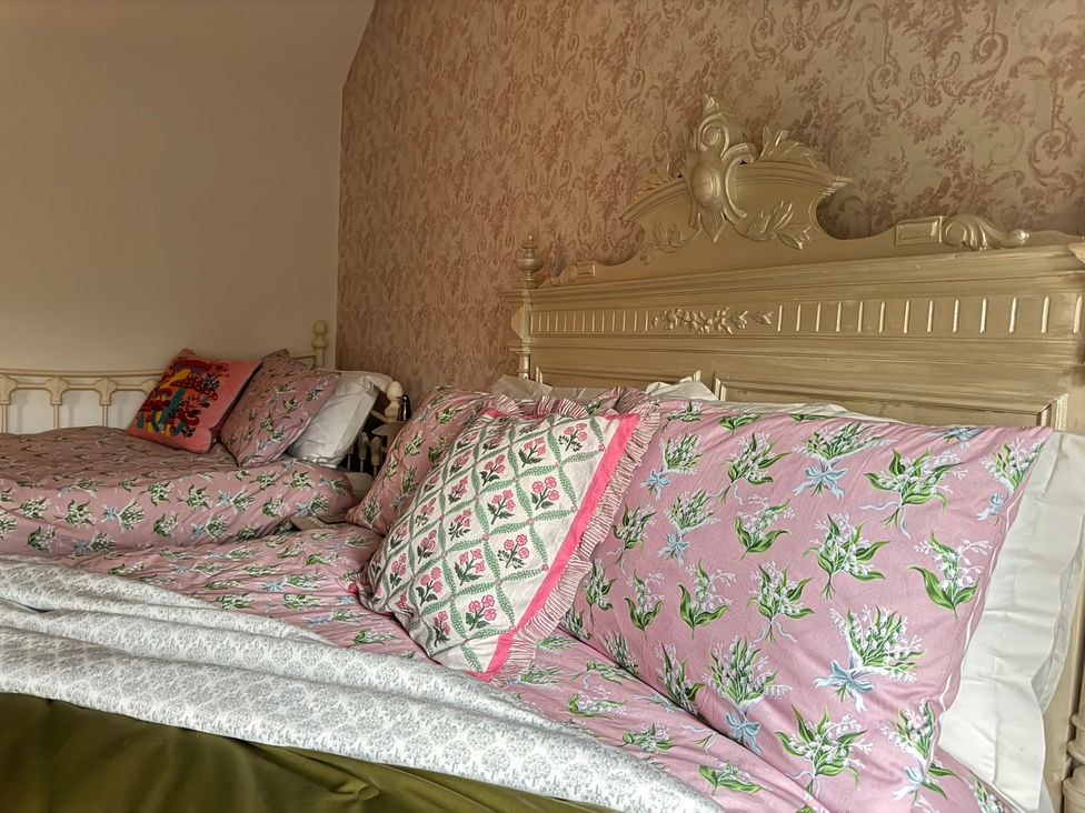 A bedroom with two beds and decorative pillows at Bradshaw House in Castleton, Peak District