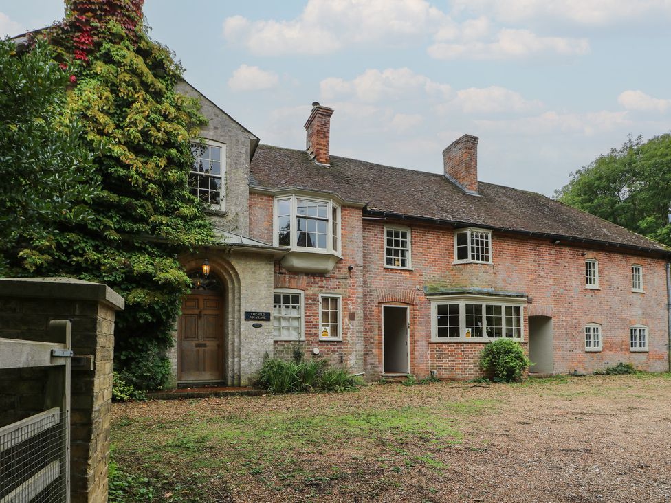 A brick house with windows and a door in a garden at The Old Vicarage