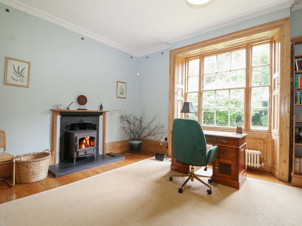 A study with a desk and chair next to a large window at Old Vicarage 