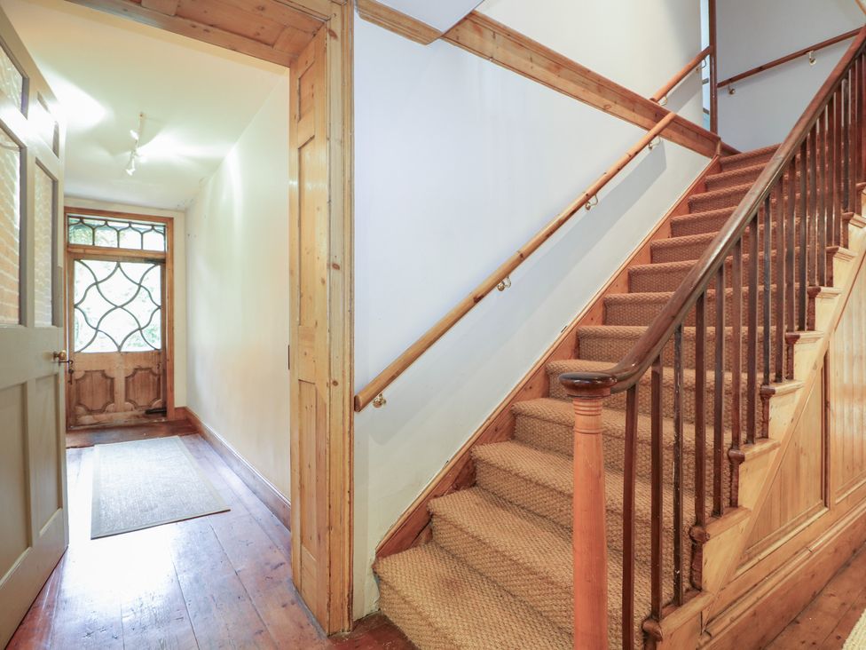 A hallway with a staircase and front door at The Old Vicarage 