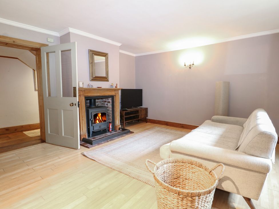 A living room with a fireplace and a sofa at Old Vicarage