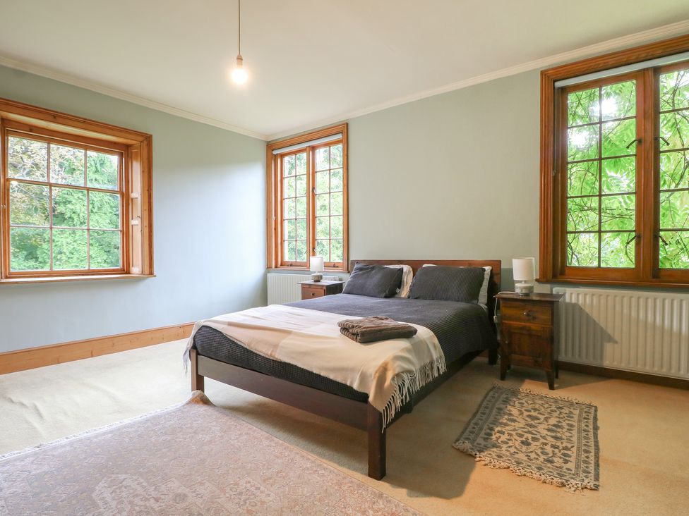 A bedroom with a bed and windows at Old Vicarage