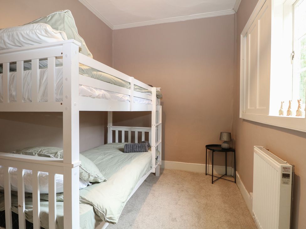 A bedroom with a bunk bed and a small table at The Old Vicarage in 