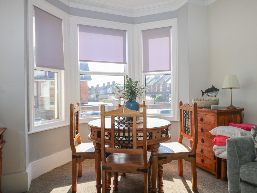 A dining room with a table and chairs at Pebbles in Eastbourne