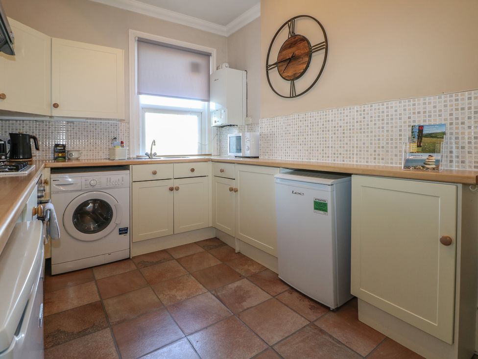 A kitchen with a washing machine and refrigerator at Pebbles in Eastbourne