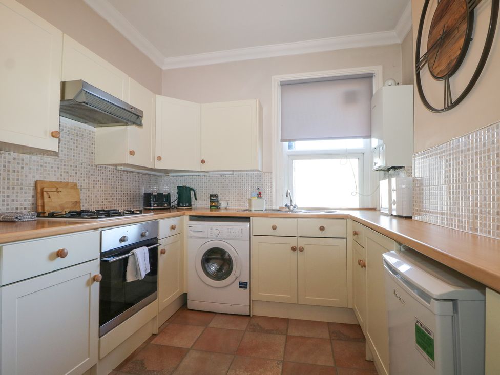 A kitchen with appliances and a window at Pebbles in Eastbourne