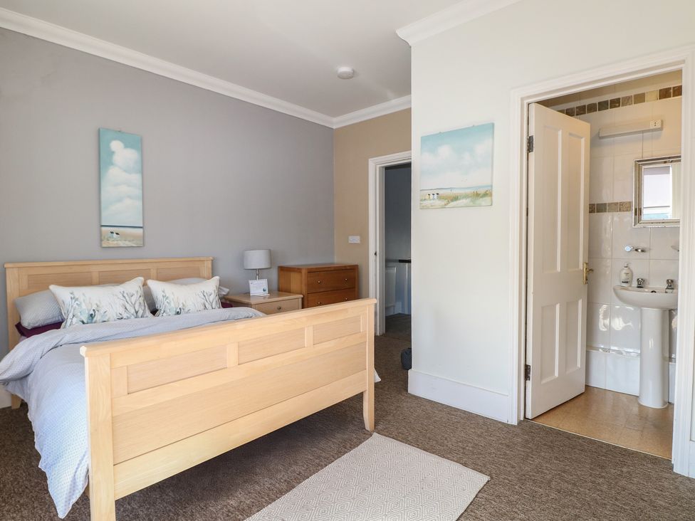 A bedroom with a bed and a bathroom door at Pebbles in Eastbourne