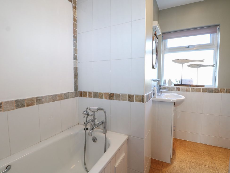 A bathroom with a bathtub and sink at Pebbles in Eastbourne