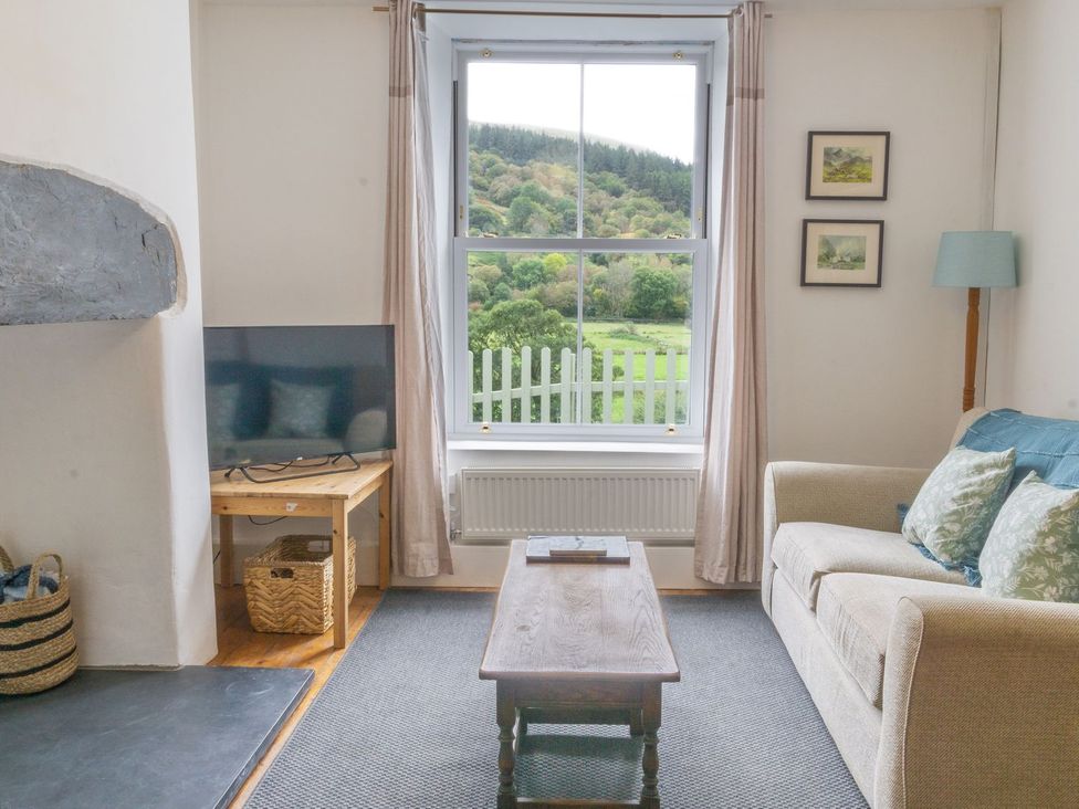 A living room with a television and coffee table at Haulfryn in Dolwyddelan