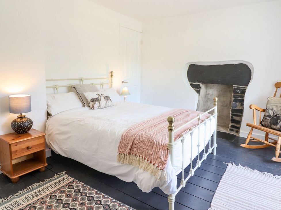 A bedroom with a bed and a rocking chair at Haulfryn in Dolwyddelan