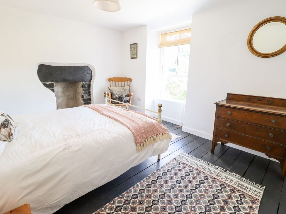 A bedroom with a bed, chair, and dresser at Haulfryn in Dolwyddelan