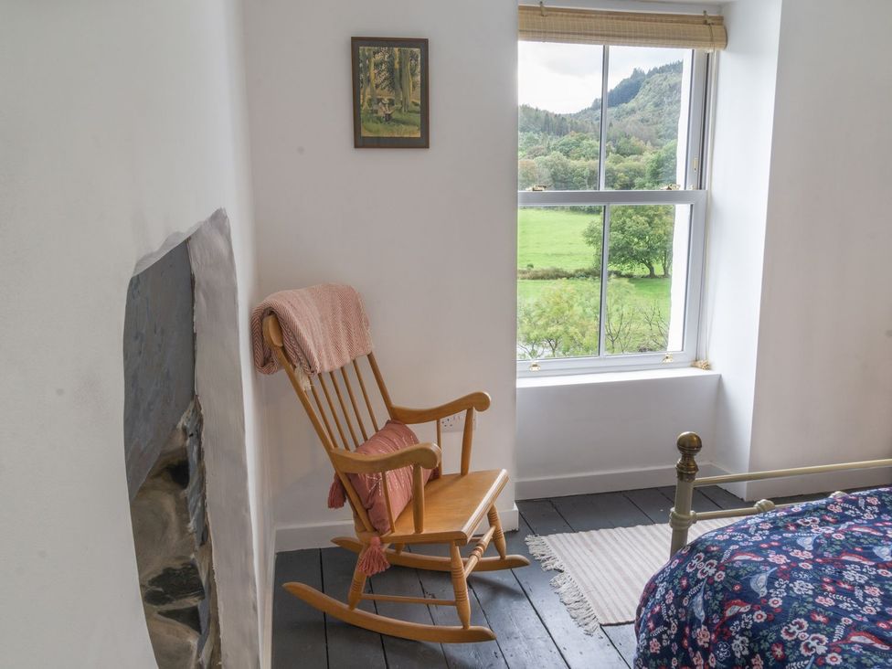 A bedroom with a rocking chair and a bed at Haulfryn in Dolwyddelan