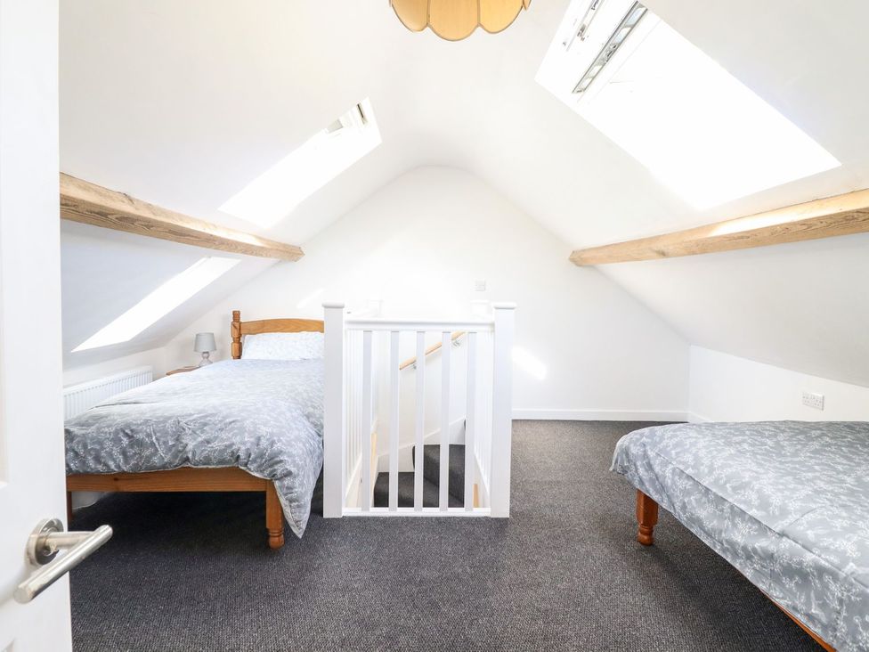 A bedroom with two beds and a staircase at Haulfryn in Dolwyddelan