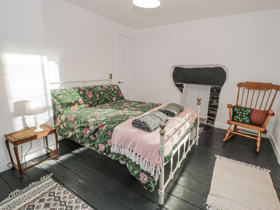 A bedroom with a bed and rocking chair at Haulfryn in Dolwyddelan