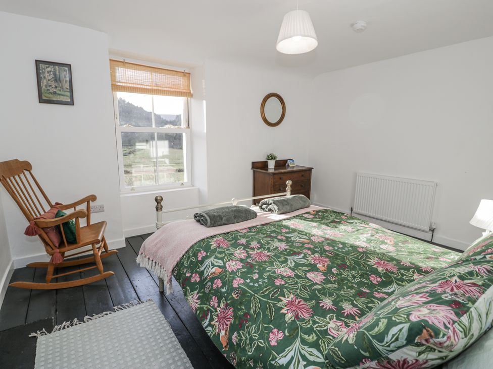 A bedroom with a bed and a rocking chair at Haulfryn in Dolwyddelan