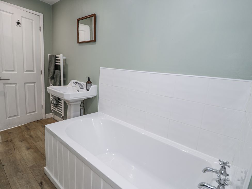 A bathroom with a bathtub, sink, and towel radiator at Haulfryn in Dolwyddelan