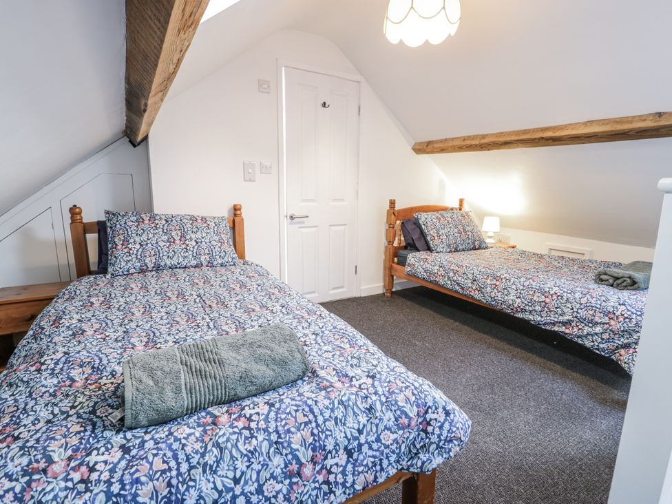 A bedroom with two beds and a wardrobe at Haulfryn Dolwyddelan