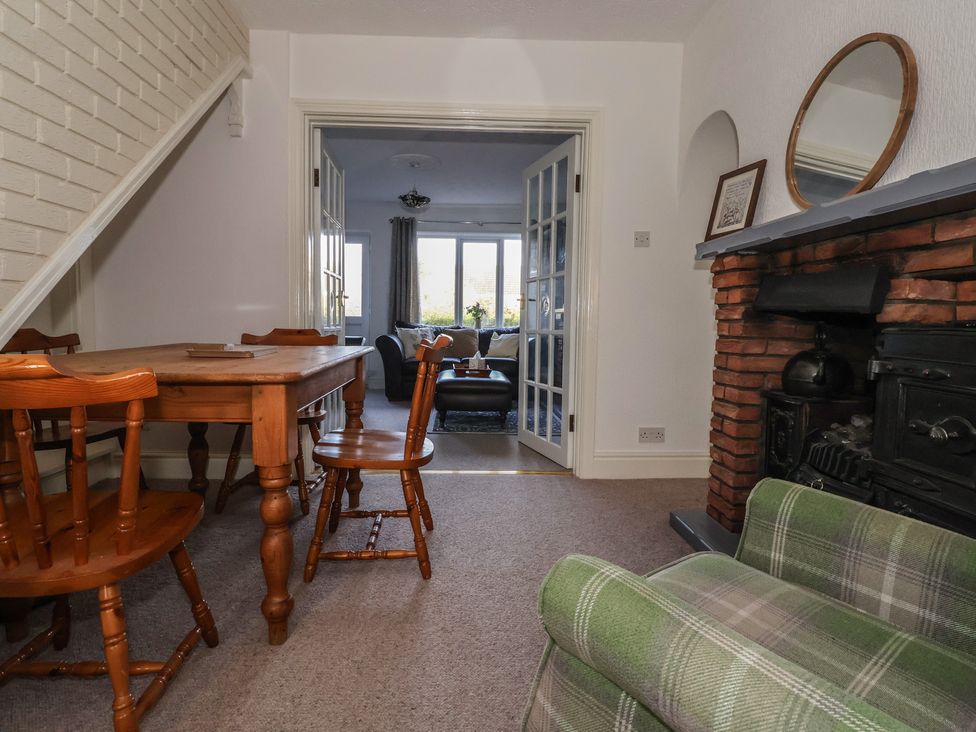 A dining room with a wooden table and chairs at Forget Me Not Cottage in Hull