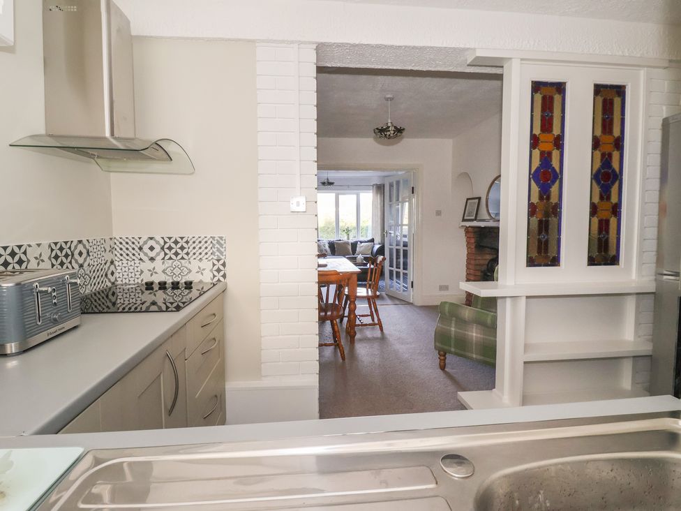 A kitchen with an extractor hood and dining area at Forget Me Not Cottage in Hull