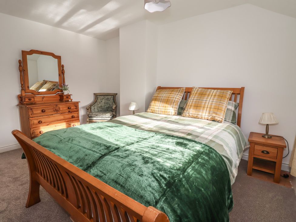 A bedroom with a bed and dressing table at Forget Me Not Cottage in Hull