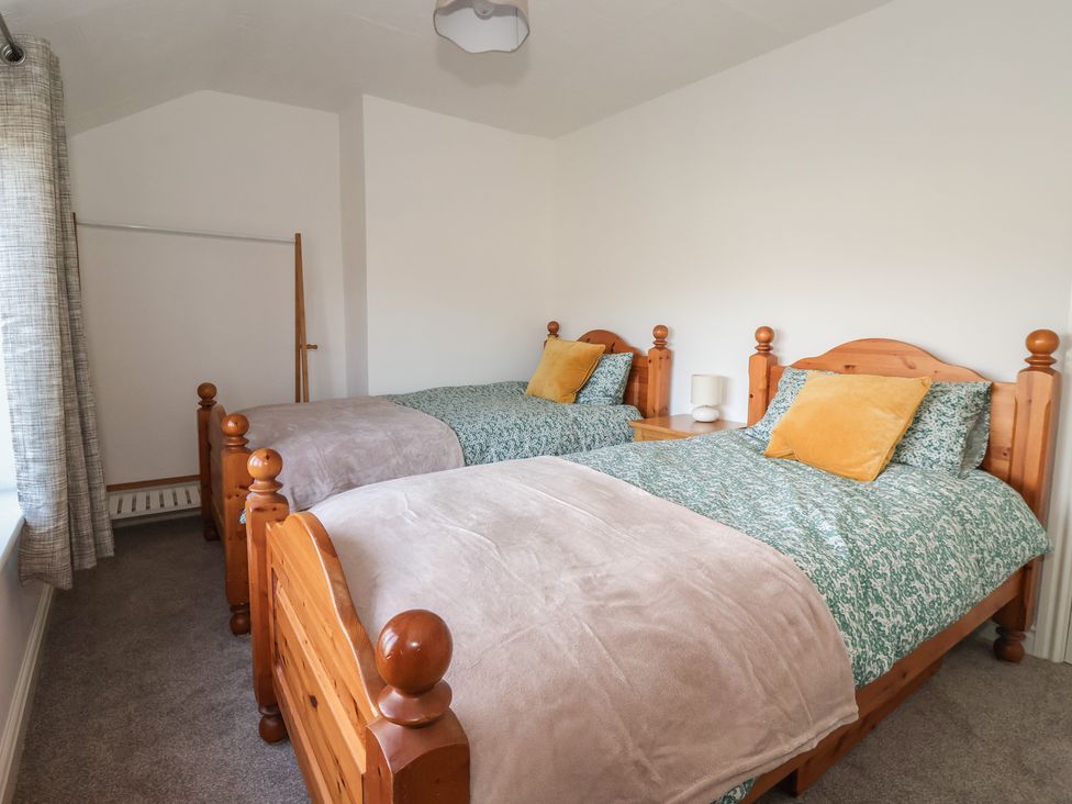 A bedroom with two beds and a wardrobe at Forget Me Not Cottage in Hull