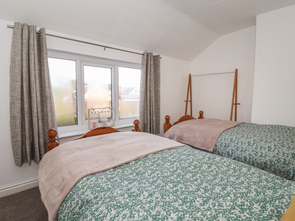A bedroom with two beds and curtains at Forget Me Not Cottage in Hull