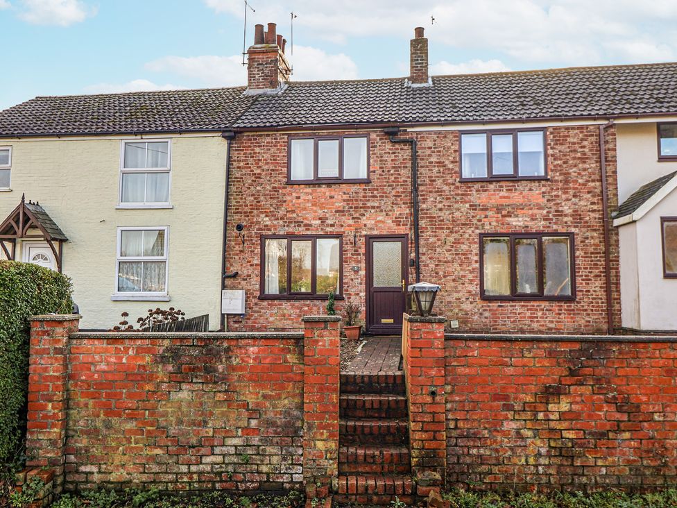 A brick house with steps and fence at Forget Me Not Cottage in Roos