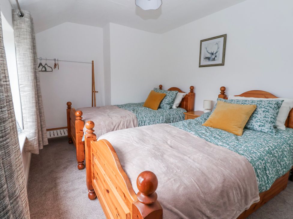 A bedroom with two beds and a closet rod at Forget Me Not Cottage Roos