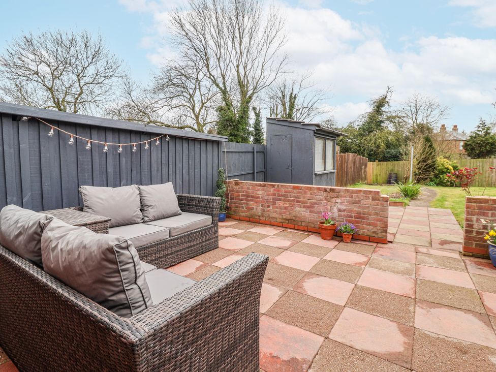 A garden with a sofa and a shed at Forget Me Not Cottage in Roos