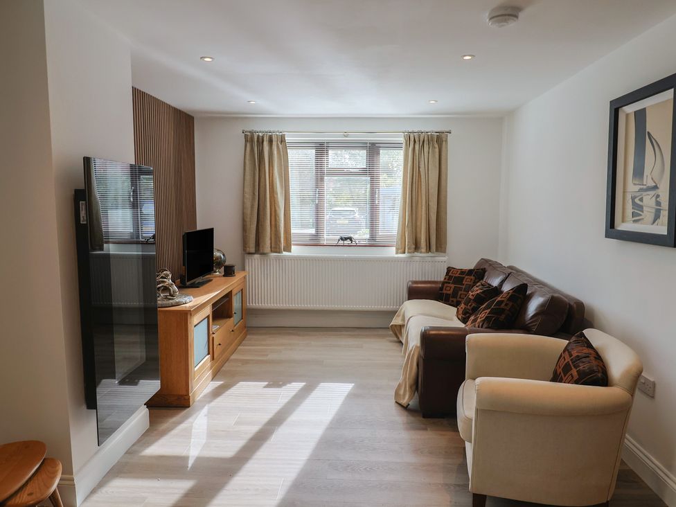 A living room with a sofa and television at Arum in Portland Bill