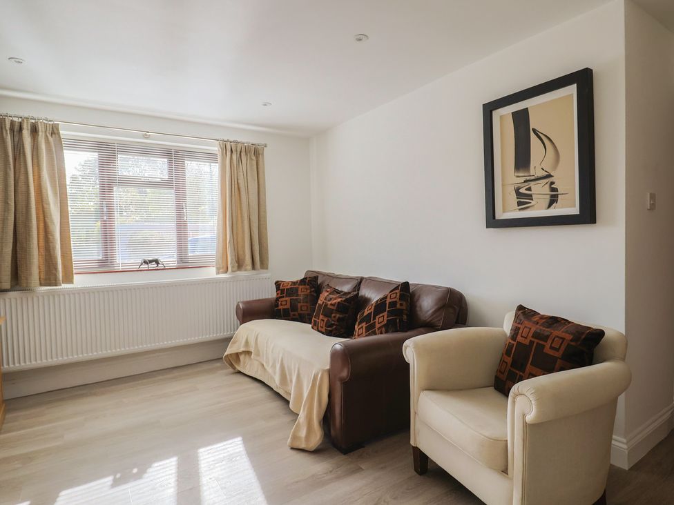 A living room with a sofa and armchair at Arum in Portland Bill