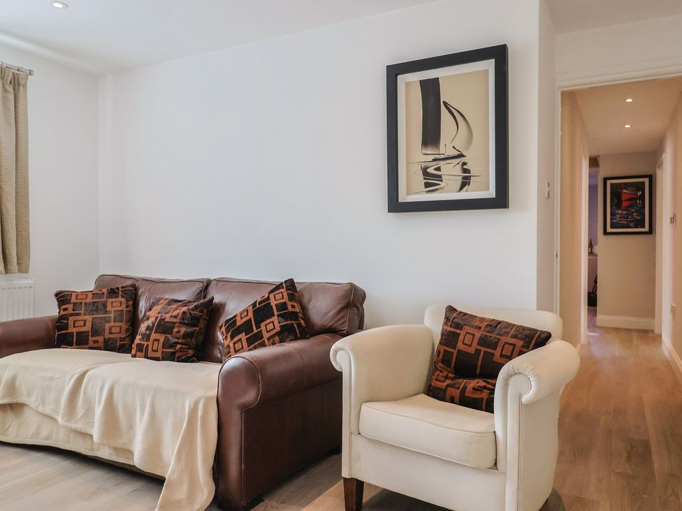 A living room with a sofa and armchair at Arum in Portland Bill