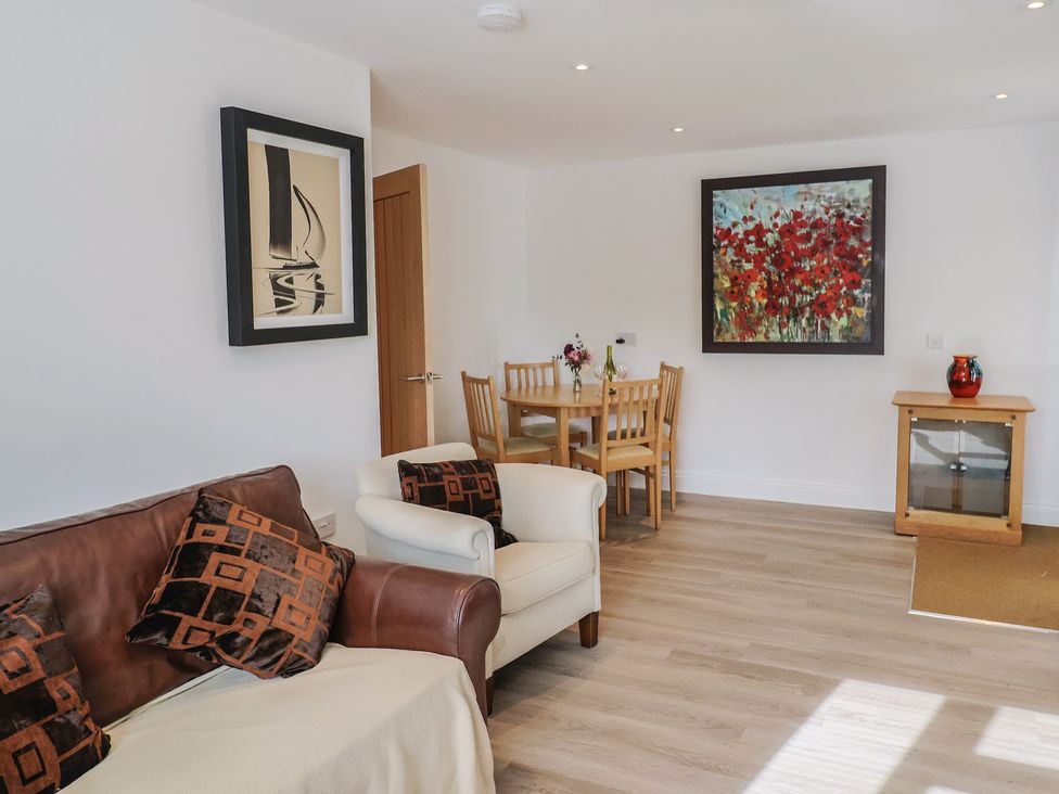 A living room with a table and chairs at Arum in Portland Bill