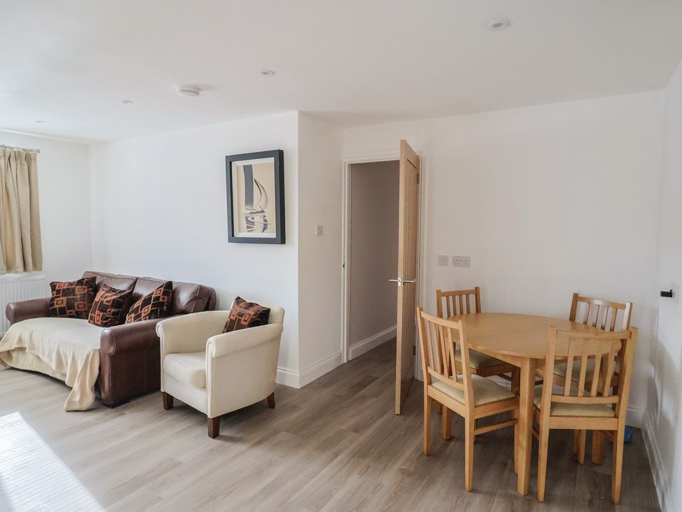 A living room with a sofa and dining table at Arum Portland Bill