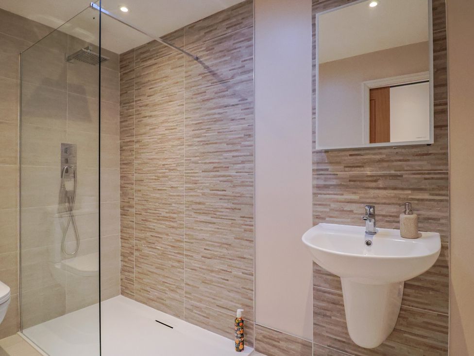 A bathroom with a shower, toilet, and sink at Arum in Portland Bill