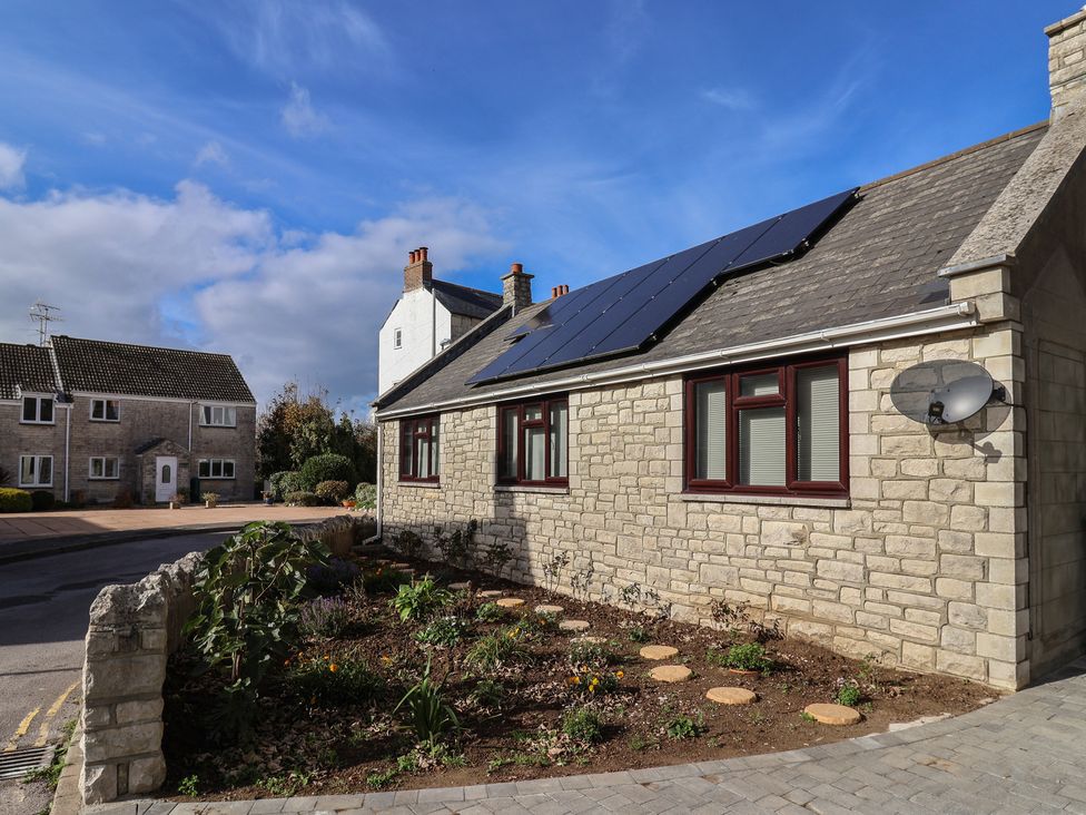 An exterior view of a house with solar panels and a garden at Arum in Portland Bill