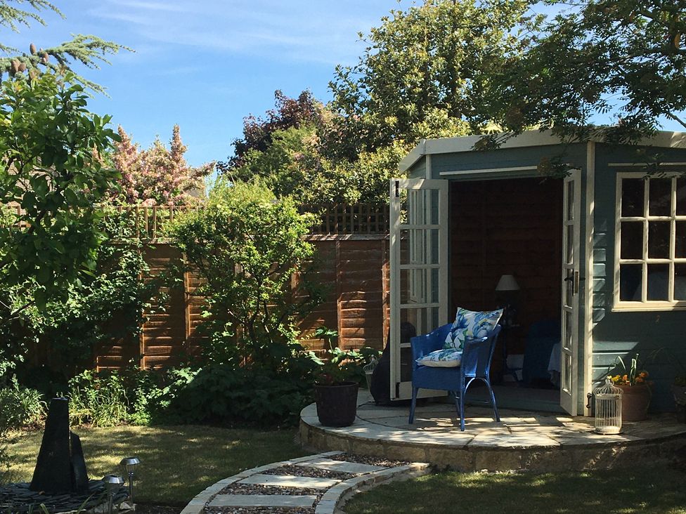 A garden with a shed and chair at Evergreen in Broadway