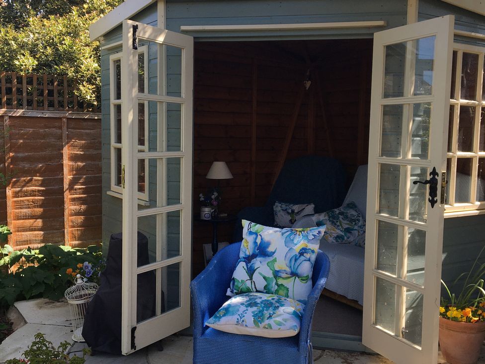A garden shed with a sofa and chair at Evergreen in Broadway