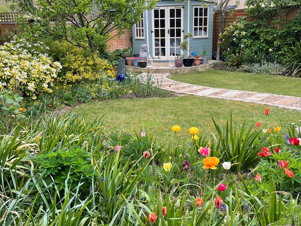 A garden with flowers and a shed at Evergreen in Broadway