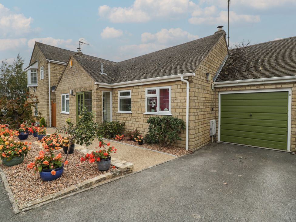 A house with a garage and flower beds at Evergreen in Broadway