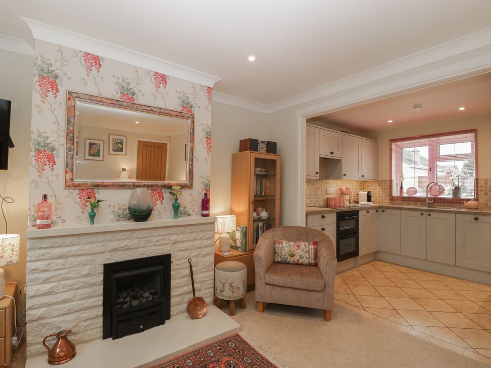 A living room with a fireplace and kitchen view at Evergreen in Broadway