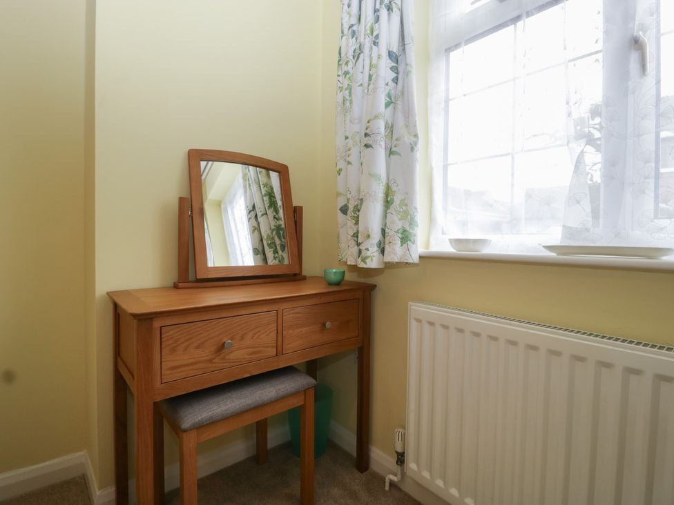 A vanity table with a mirror and stool at Evergreen in Broadway