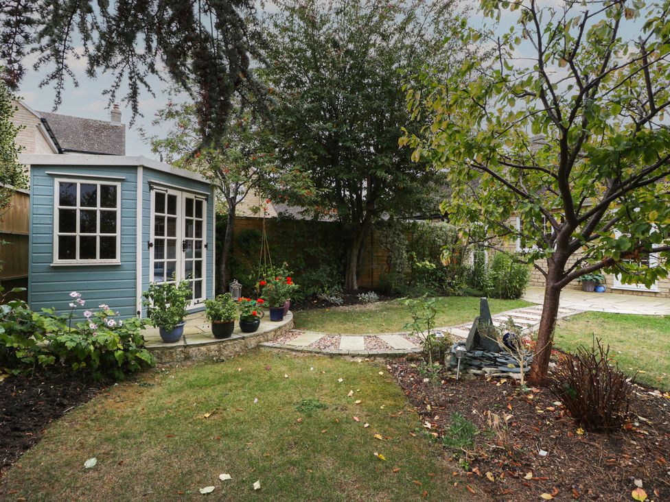 A garden with a shed and flowerpots at Evergreen in Broadway