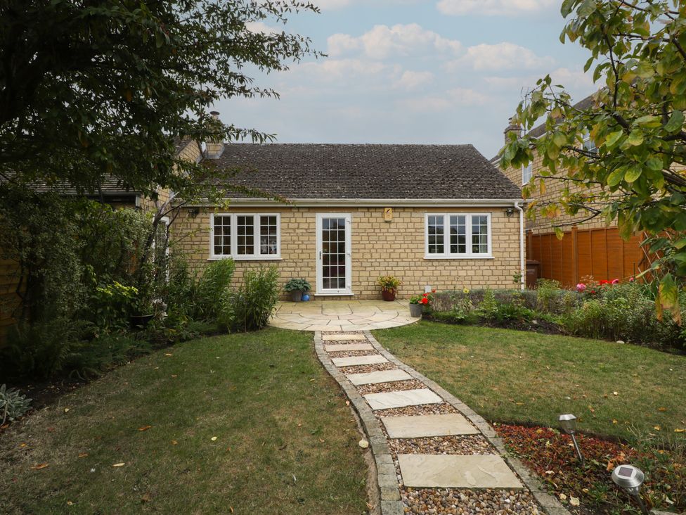 A garden with a pathway leading to a house at Evergreen in Broadway