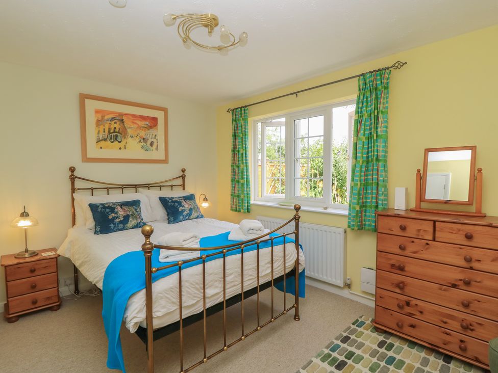 A bedroom with a bed and wooden furniture at Evergreen in Broadway