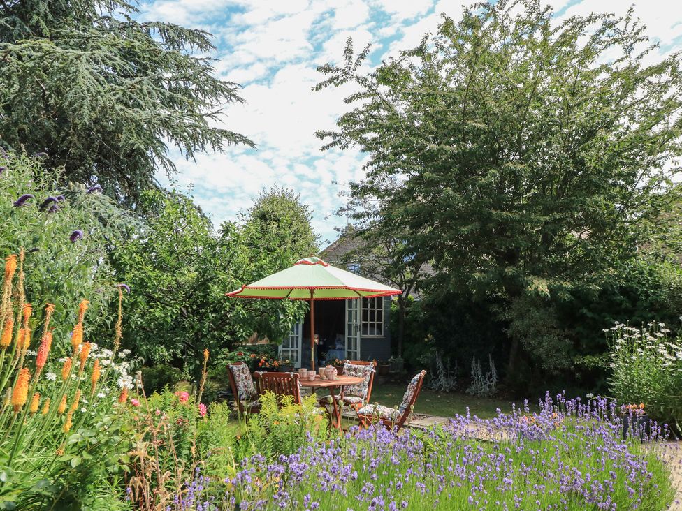 A garden with a table and chairs under an umbrella at Evergreen in Broadway